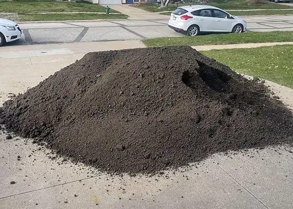 pile of dirt on the driveway