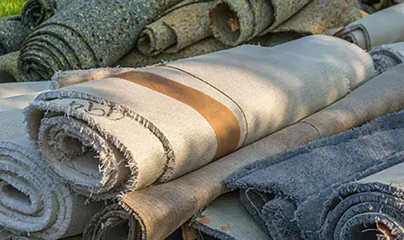 old carpeting and padding rolled into small rolls for removal